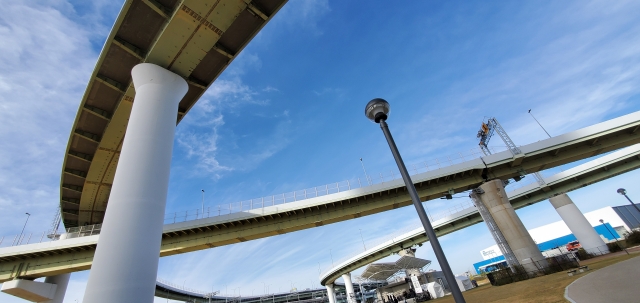 高速道路のジャンクションを見て、高度経済成長を実現した田中角栄の功績を回想しているイメージ写真